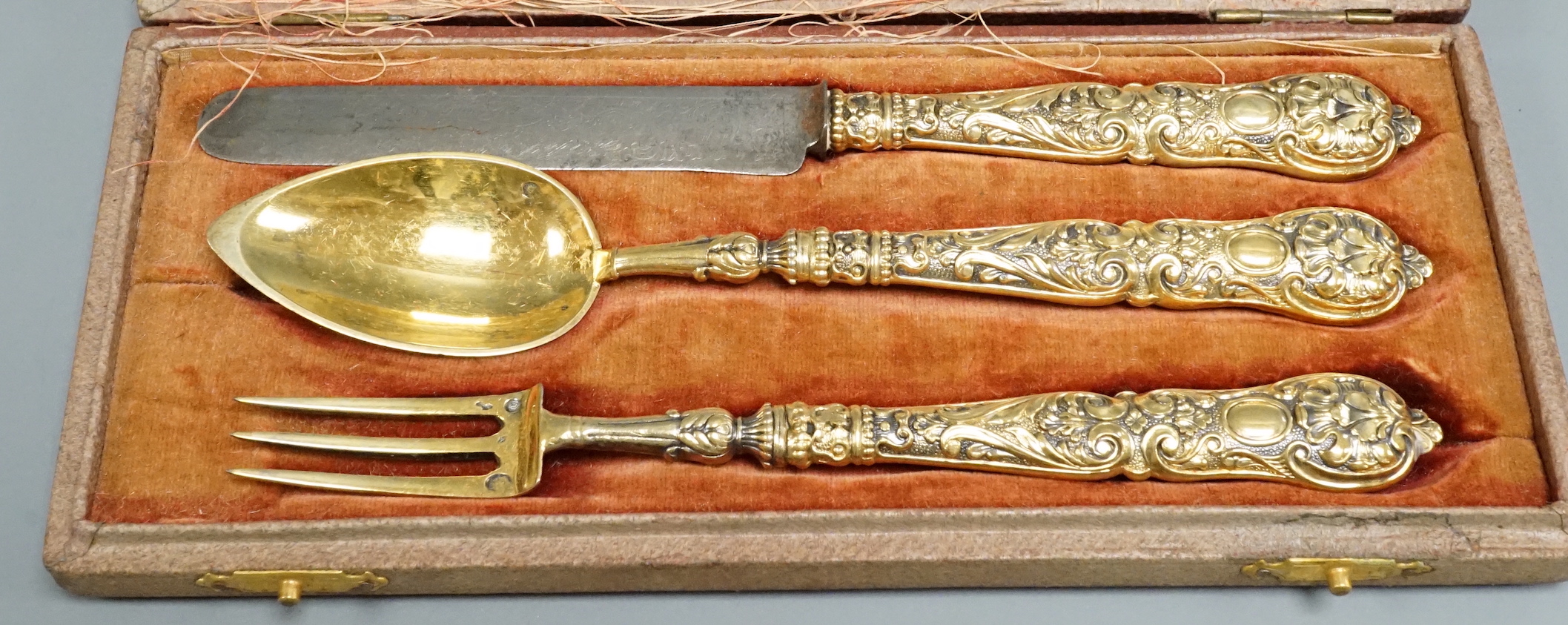 A leather cased early 19th century gilt white metal three piece cutlery set, knife 18.1cm.
